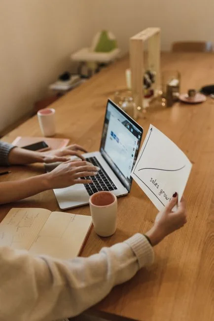 Équipe analysant des graphiques financiers et des données numériques sur des tablettes dans un environnement de bureau.