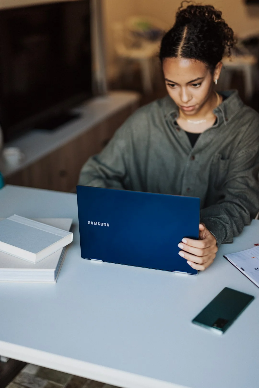 A modern workspace showing hands analyzing marketing data on a laptop and paper documents.